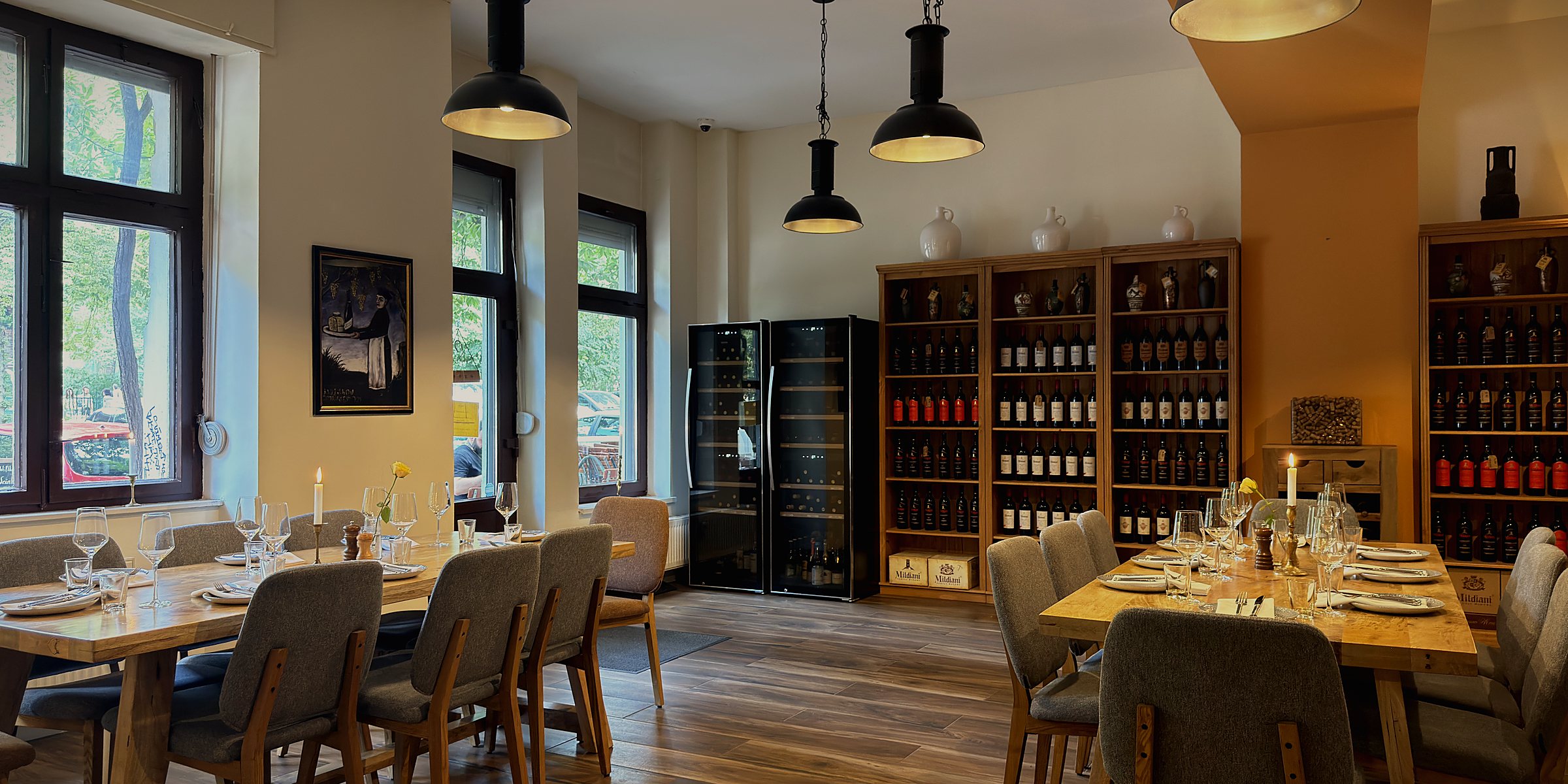 The full room at Weinhaus Tbilisi, wine shelves along both walls and daylight from the street windows