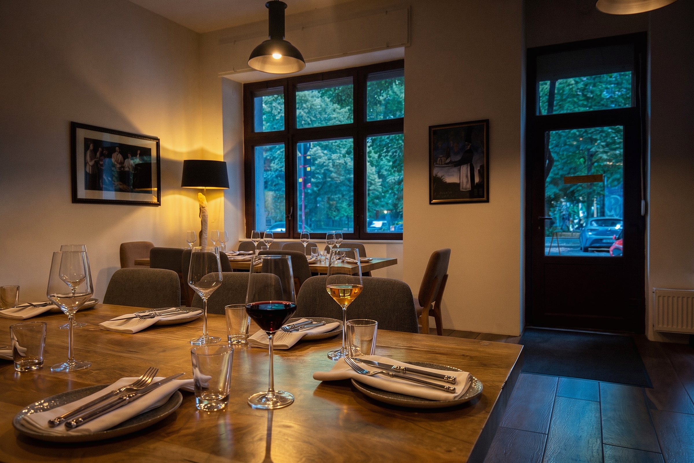 The front room at Weinhaus Tbilisi in the evening, the table laid and two glasses poured